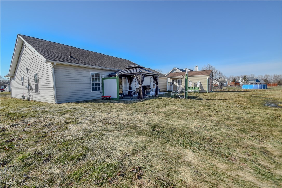 643 Wood Ridge Road Geneva, OH 44041 - Photo 22 of 24 Rear view of property featuring a gazebo, a shingled roof, and a lawn