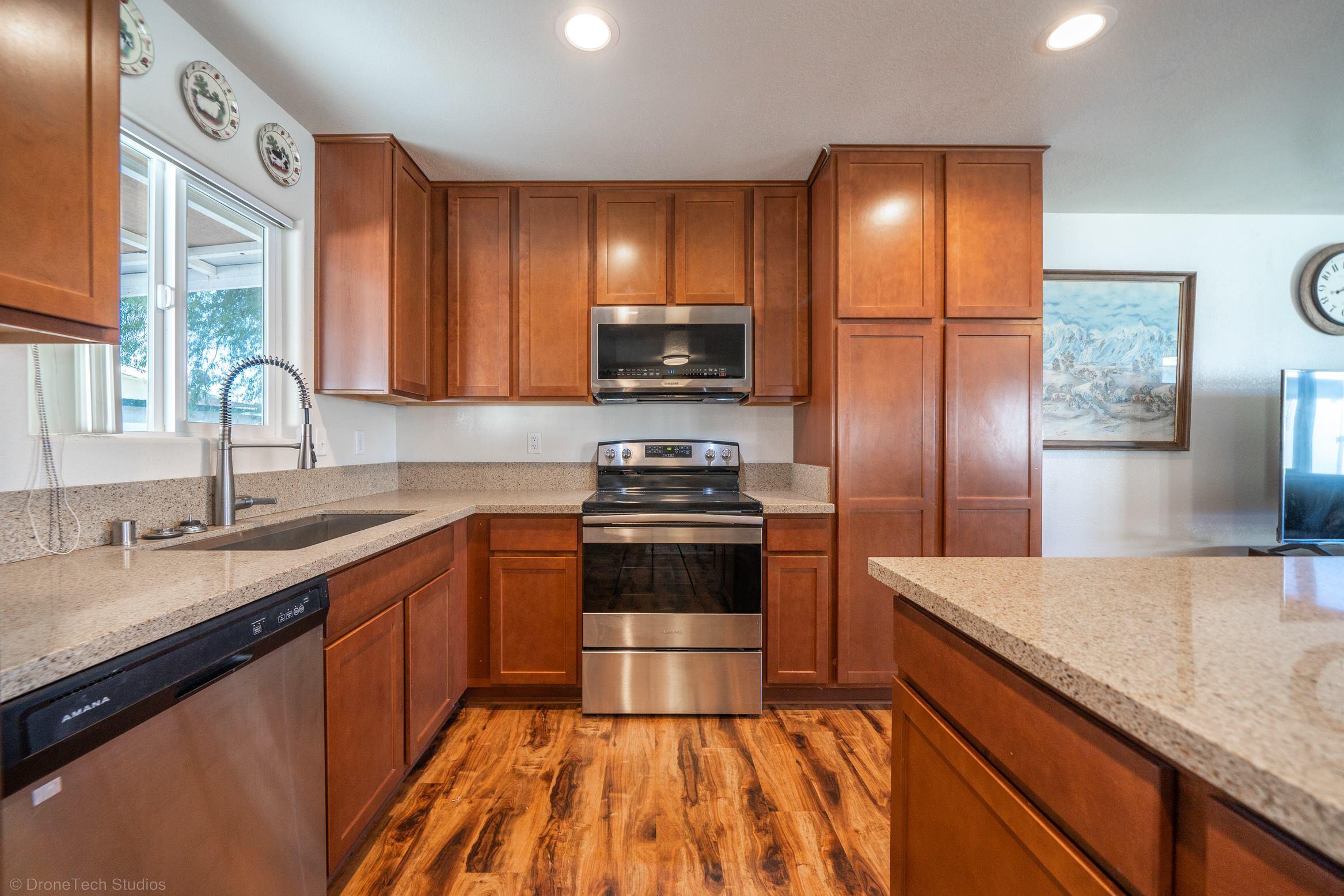 1025 Beltline Road Redding, CA 96003 - Photo 8 of 37 a kitchen with stainless steel appliances granite countertop a sink a stove and a refrigerator