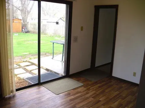 a view of an empty room and wooden floor and windows