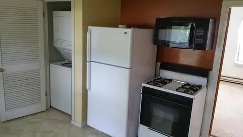 a white refrigerator freezer and a stove sitting inside of a kitchen