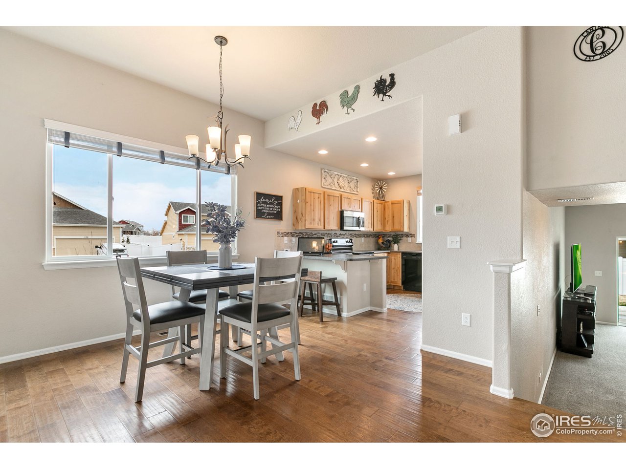 528 El Diente Avenue Severance, CO 80550 - Photo 3 of 19 a dining room with stainless steel appliances kitchen island granite countertop a table chairs and a refrigerator