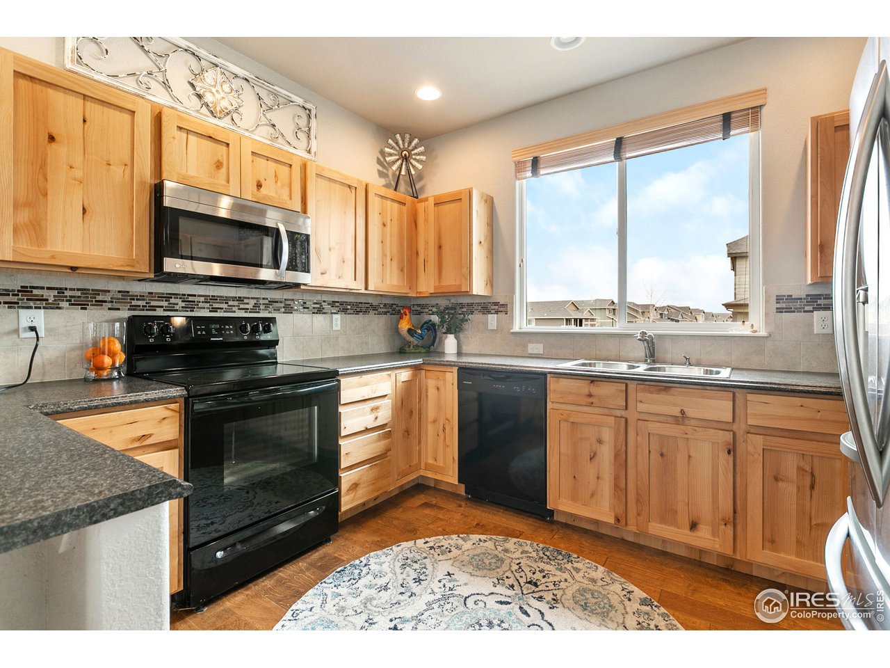528 El Diente Avenue Severance, CO 80550 - Photo 6 of 19 a kitchen with stainless steel appliances granite countertop a stove microwave and cabinets