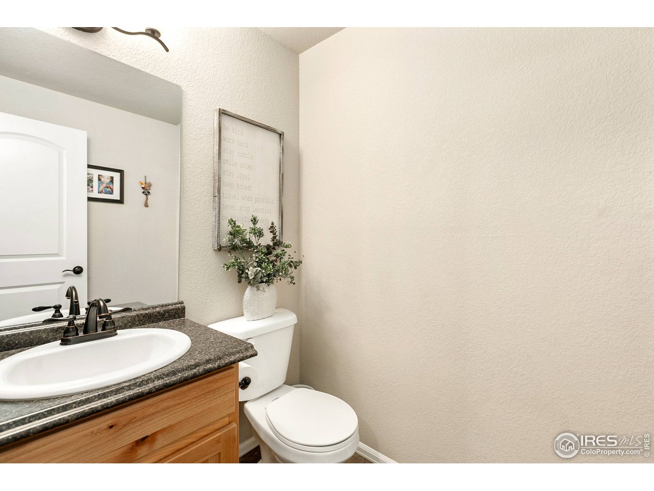 528 El Diente Avenue Severance, CO 80550 - Photo 7 of 19 a bathroom with a granite countertop toilet sink and mirror