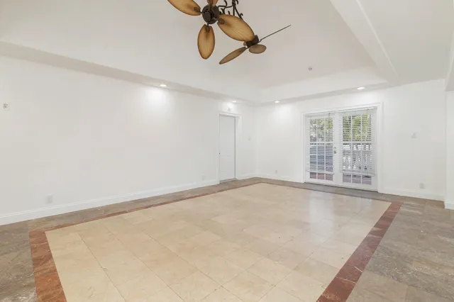 a view of empty room with wooden floor and ceiling fan