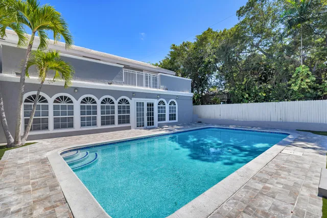 a view of an house with backyard and swimming pool
