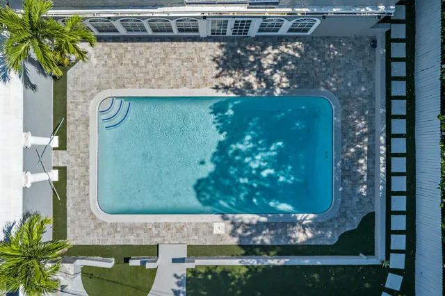 an aerial view of residential houses with outdoor space and trees