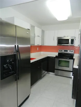 a kitchen with stainless steel appliances kitchen island a stove and a refrigerator