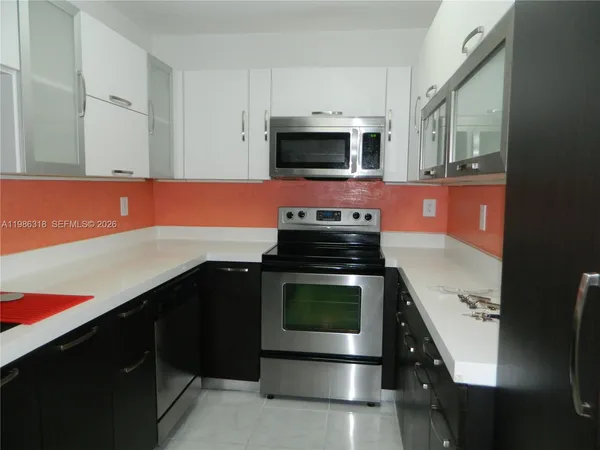 a kitchen with stainless steel appliances a stove microwave and sink