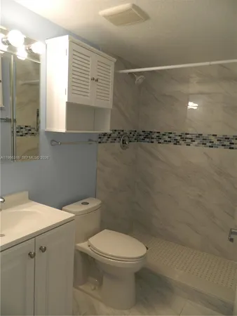 a bathroom with a toilet sink and shower