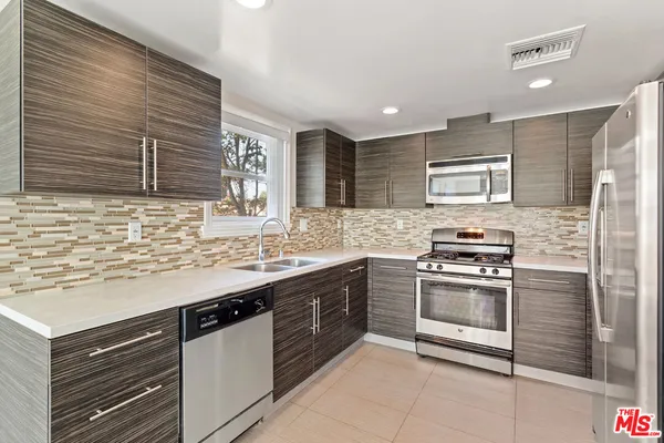 a kitchen with stainless steel appliances granite countertop a sink and stove