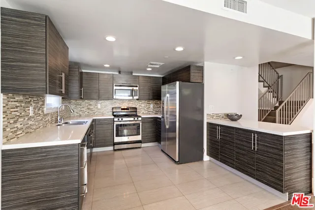 a kitchen with granite countertop a refrigerator and a stove