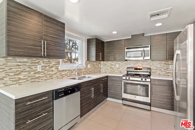 a kitchen with stainless steel appliances granite countertop a sink and stove