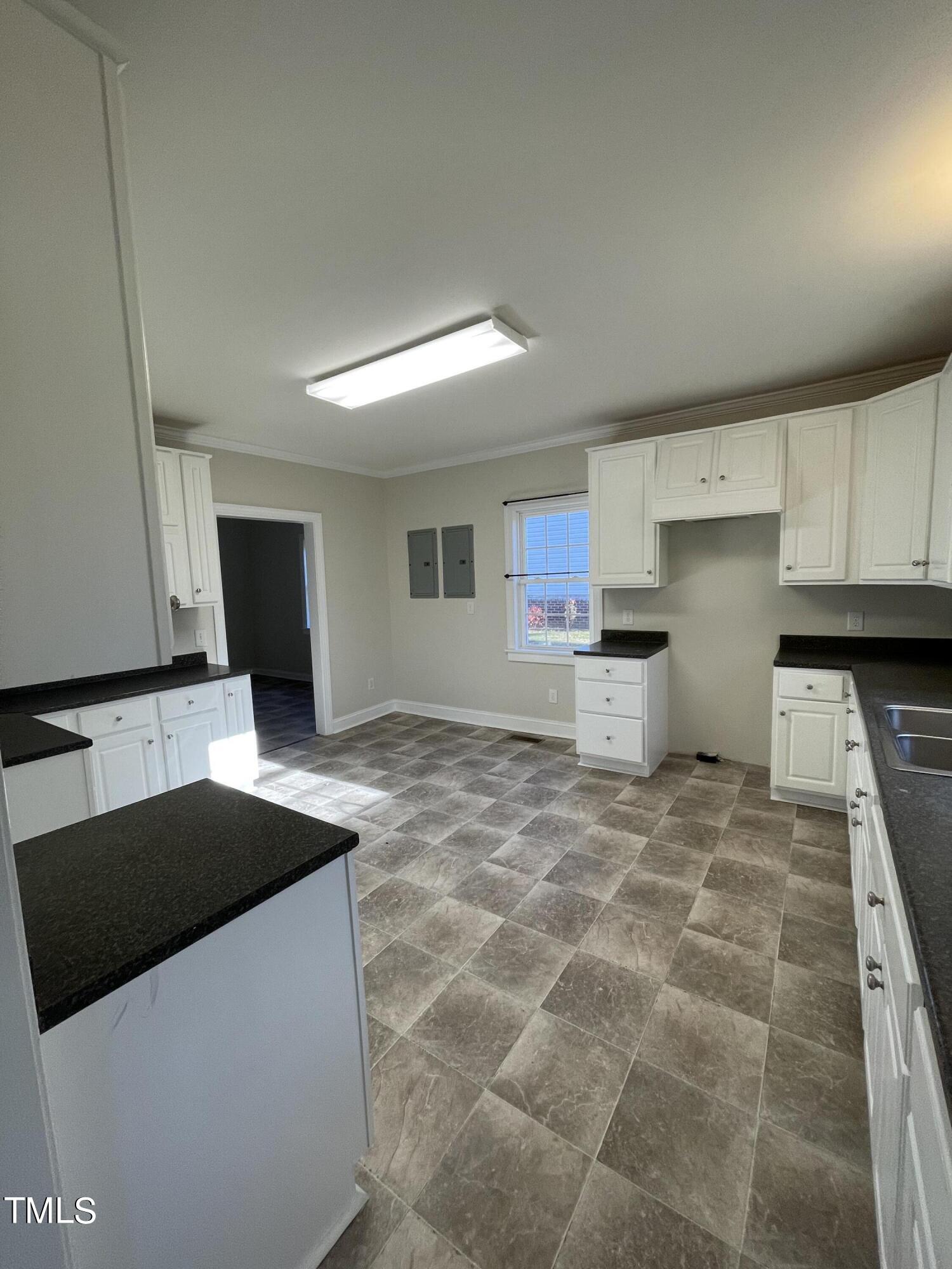 119 Academy Street Roxboro, NC 27573 - Photo 13 of 22 a kitchen with granite countertop a sink a stove and cabinets