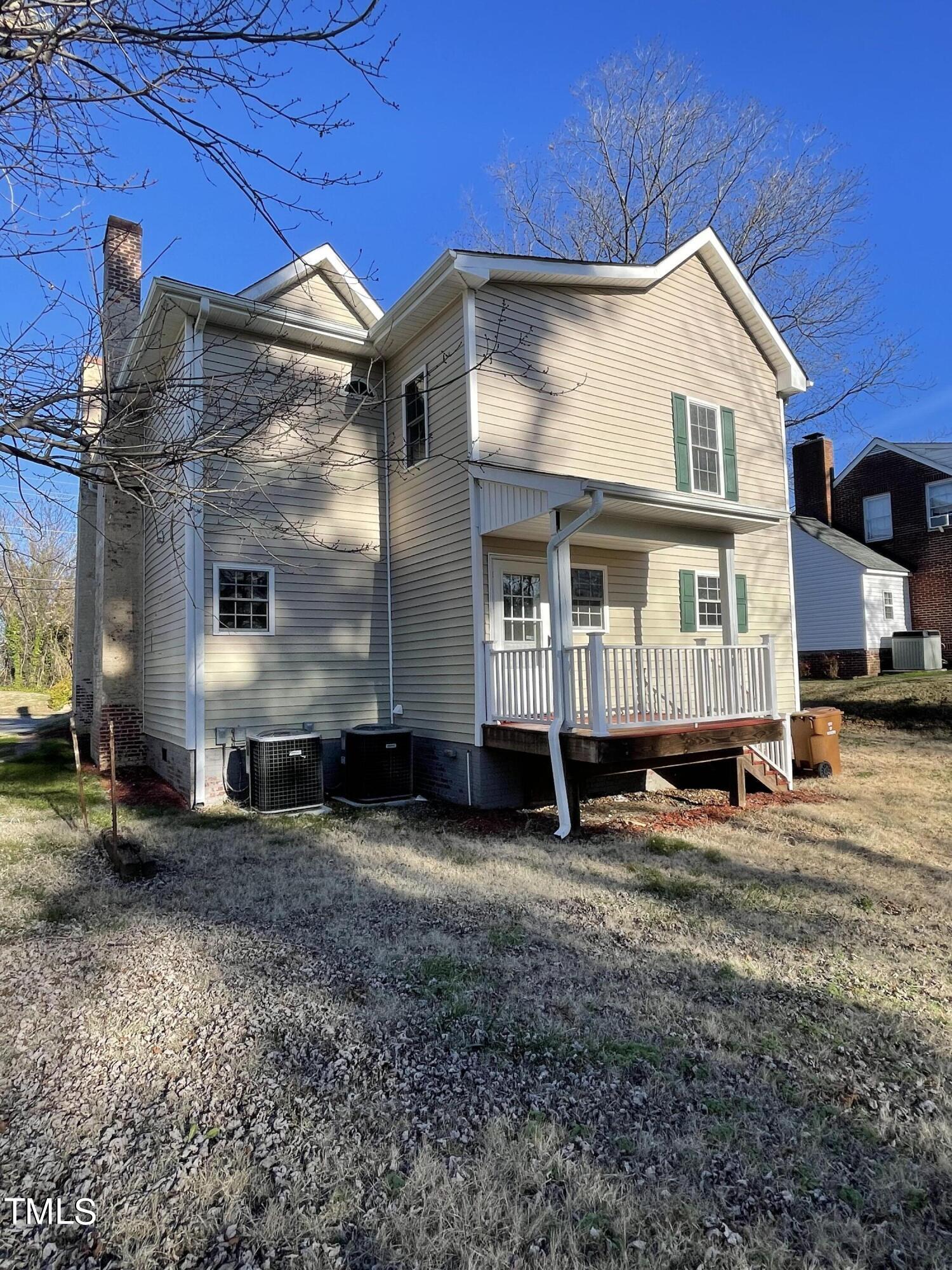 119 Academy Street Roxboro, NC 27573 - Photo 2 of 22 a view of a large white house with large windows next to a yard