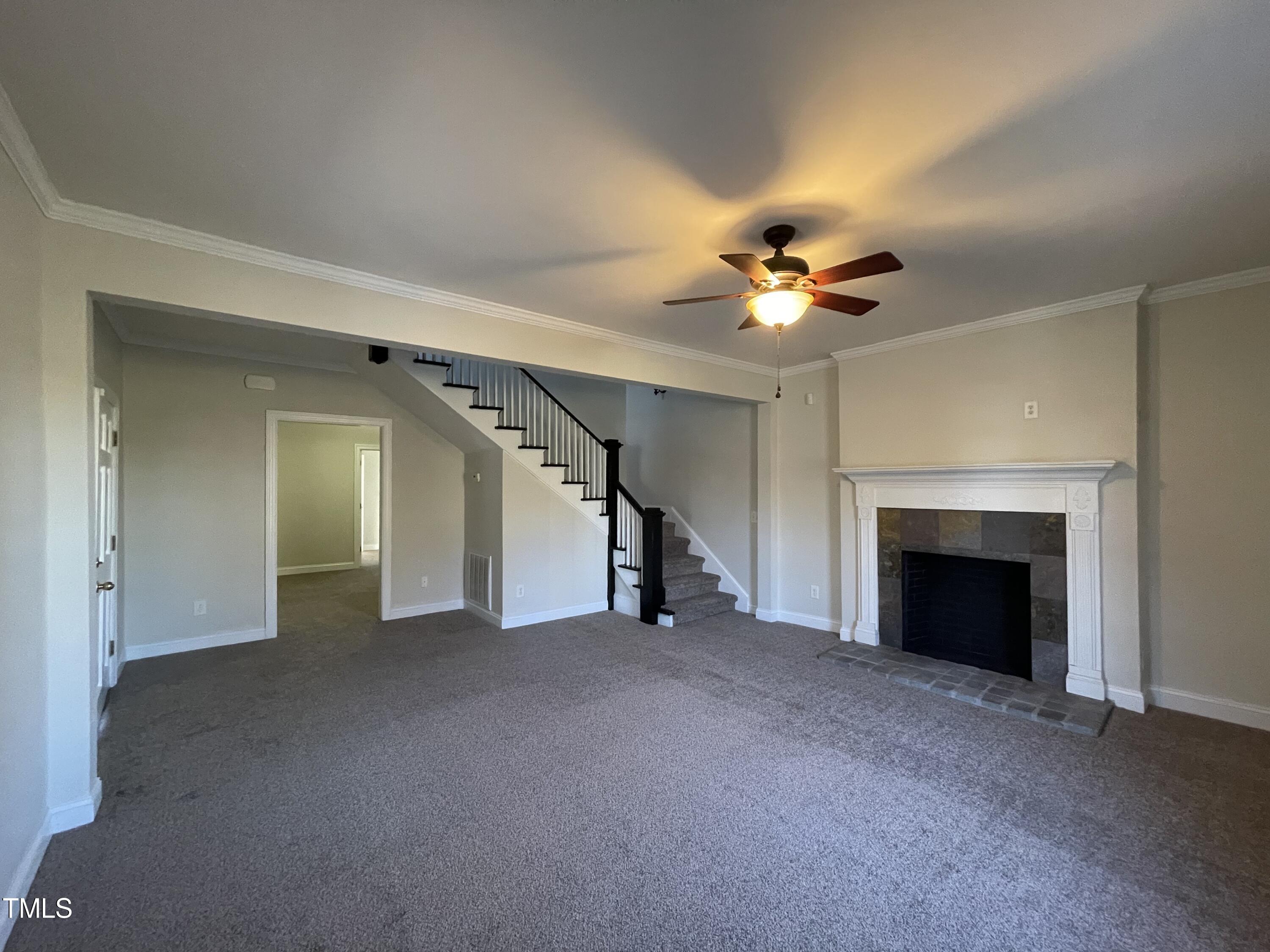 119 Academy Street Roxboro, NC 27573 - Photo 8 of 22 a view of a livingroom with a ceiling fan and a fireplace