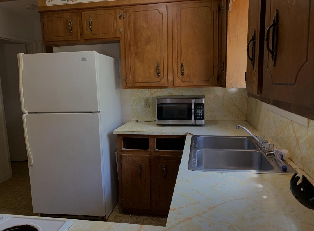 1470 Reddick Mill Road Graceville, FL 32440 - Photo 4 of 11 a white refrigerator freezer and a stove sitting inside of a kitchen