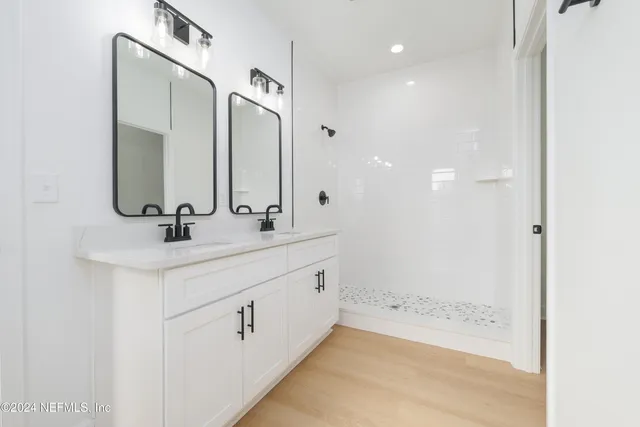 a bathroom with double vanity sink and a mirror