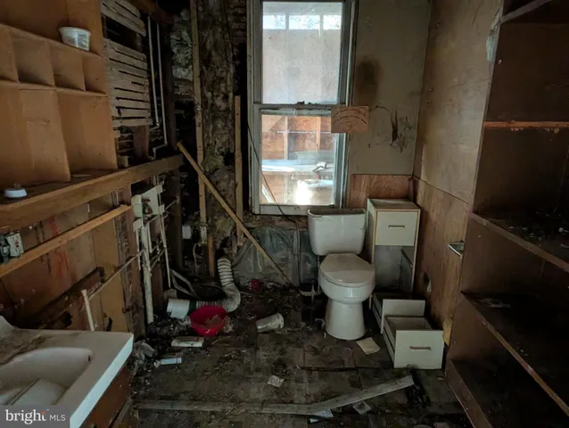 a bathroom with a toilet a sink and a mirror