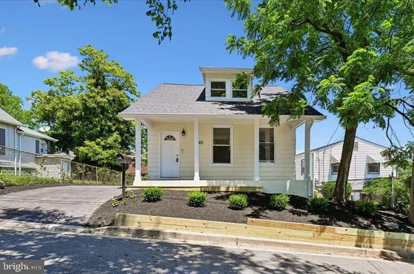 a front view of a house with a yard and potted plants