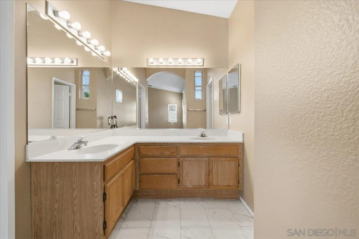 3143 Lamar Court Spring Valley, CA 91977 - Photo 15 of 40 a spacious bathroom with a granite countertop sink a mirror and a
