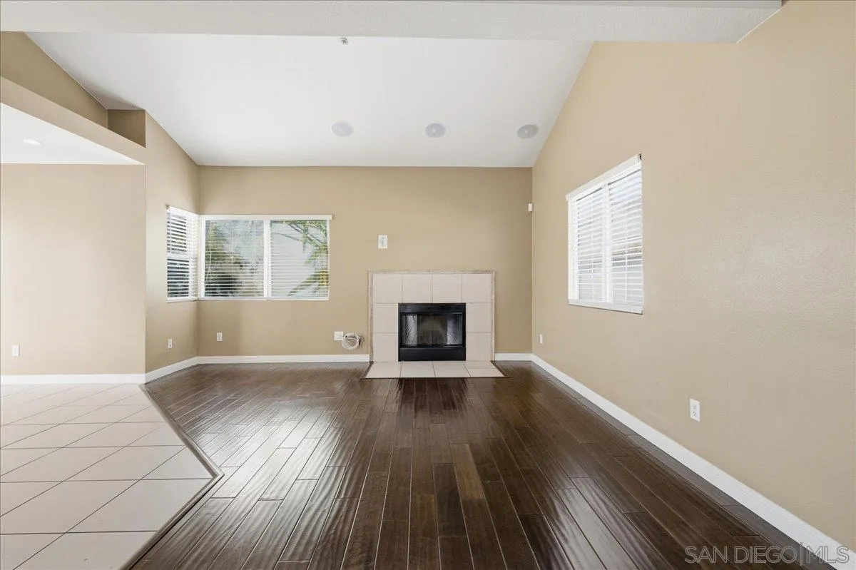 3143 Lamar Court Spring Valley, CA 91977 - Photo 4 of 40 an empty room with wooden floor a fireplace and windows