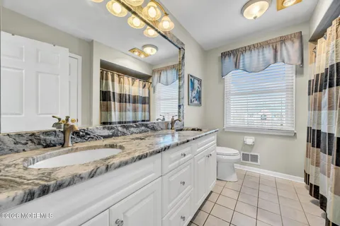 a spacious bathroom with a granite countertop tub sink a mirror a shower and vanity