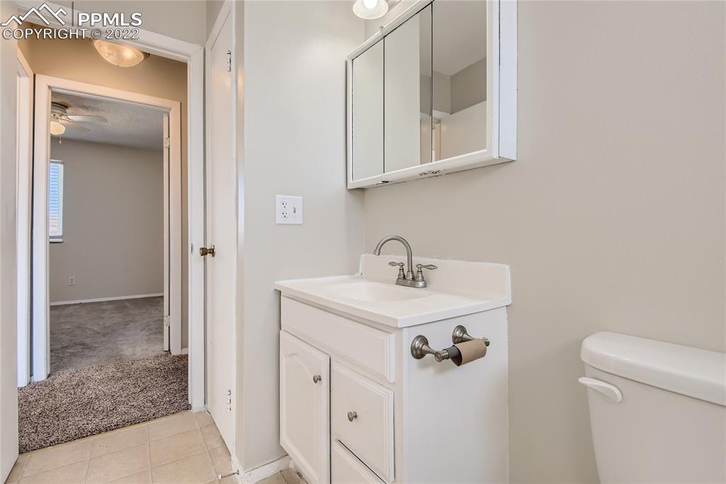 2030 Chelton Road Colorado Springs, CO 80916 - Photo 16 of 33 a bathroom with a sink a toilet and mirror