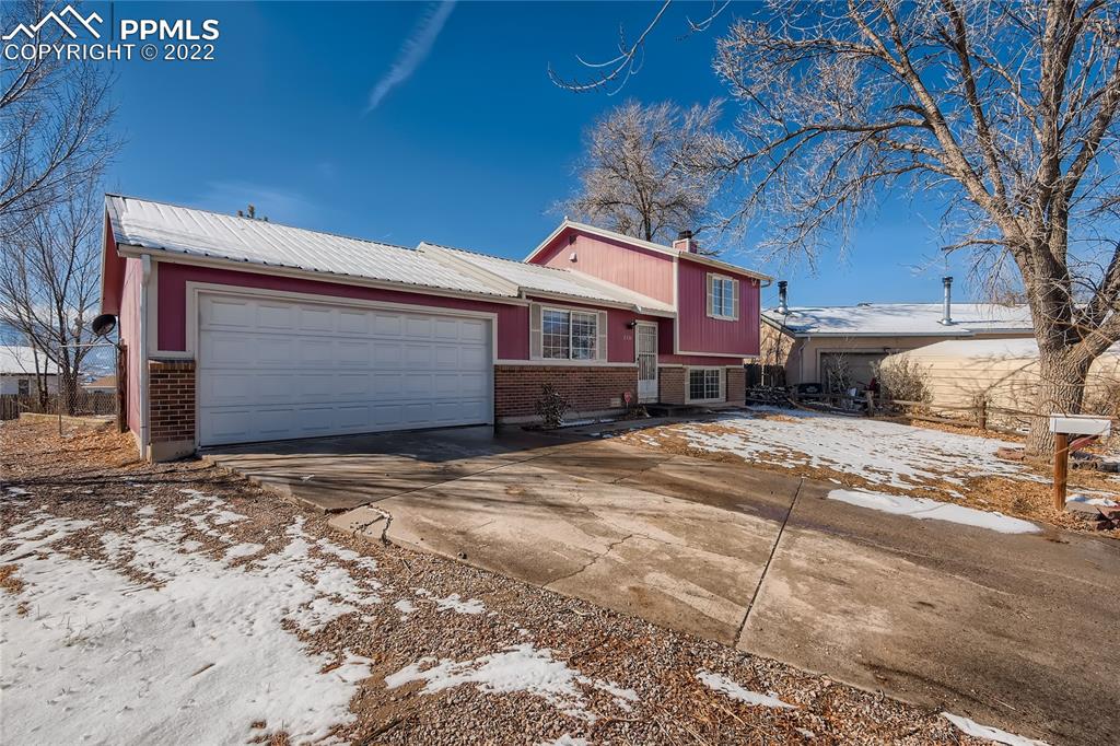 2030 Chelton Road Colorado Springs, CO 80916 - Photo 2 of 33 a front view of a house with a yard and garage