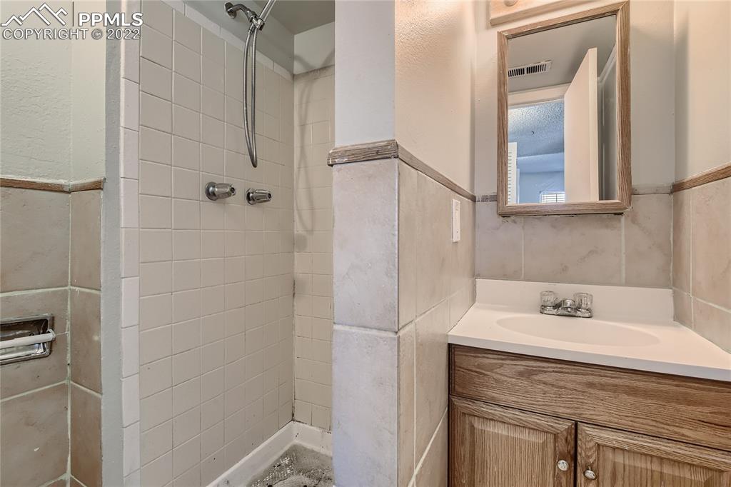 2030 Chelton Road Colorado Springs, CO 80916 - Photo 21 of 33 a bathroom with a sink and a mirror