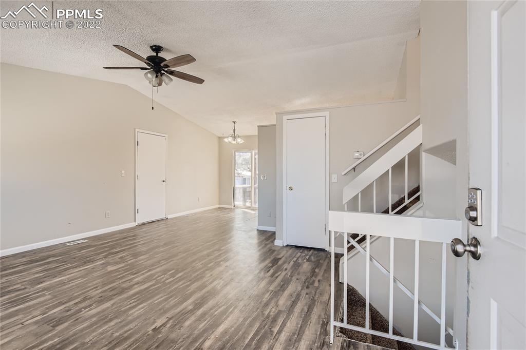 2030 Chelton Road Colorado Springs, CO 80916 - Photo 4 of 33 a view of a livingroom with wooden floor and staircase