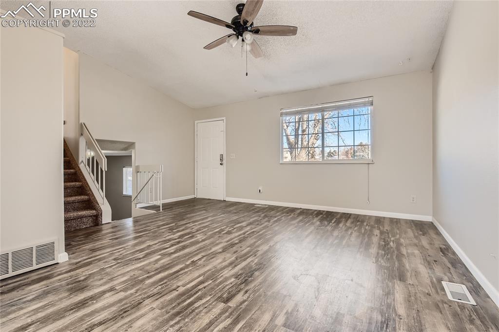 2030 Chelton Road Colorado Springs, CO 80916 - Photo 6 of 33 wooden floor in an empty room with a window