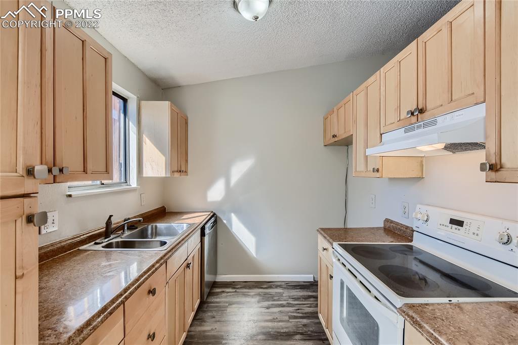 2030 Chelton Road Colorado Springs, CO 80916 - Photo 9 of 33 a kitchen with a sink stove top oven and cabinets