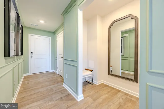 a view of a hallway with wooden floor and a living room