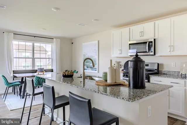 a kitchen with granite countertop a sink stove and refrigerator