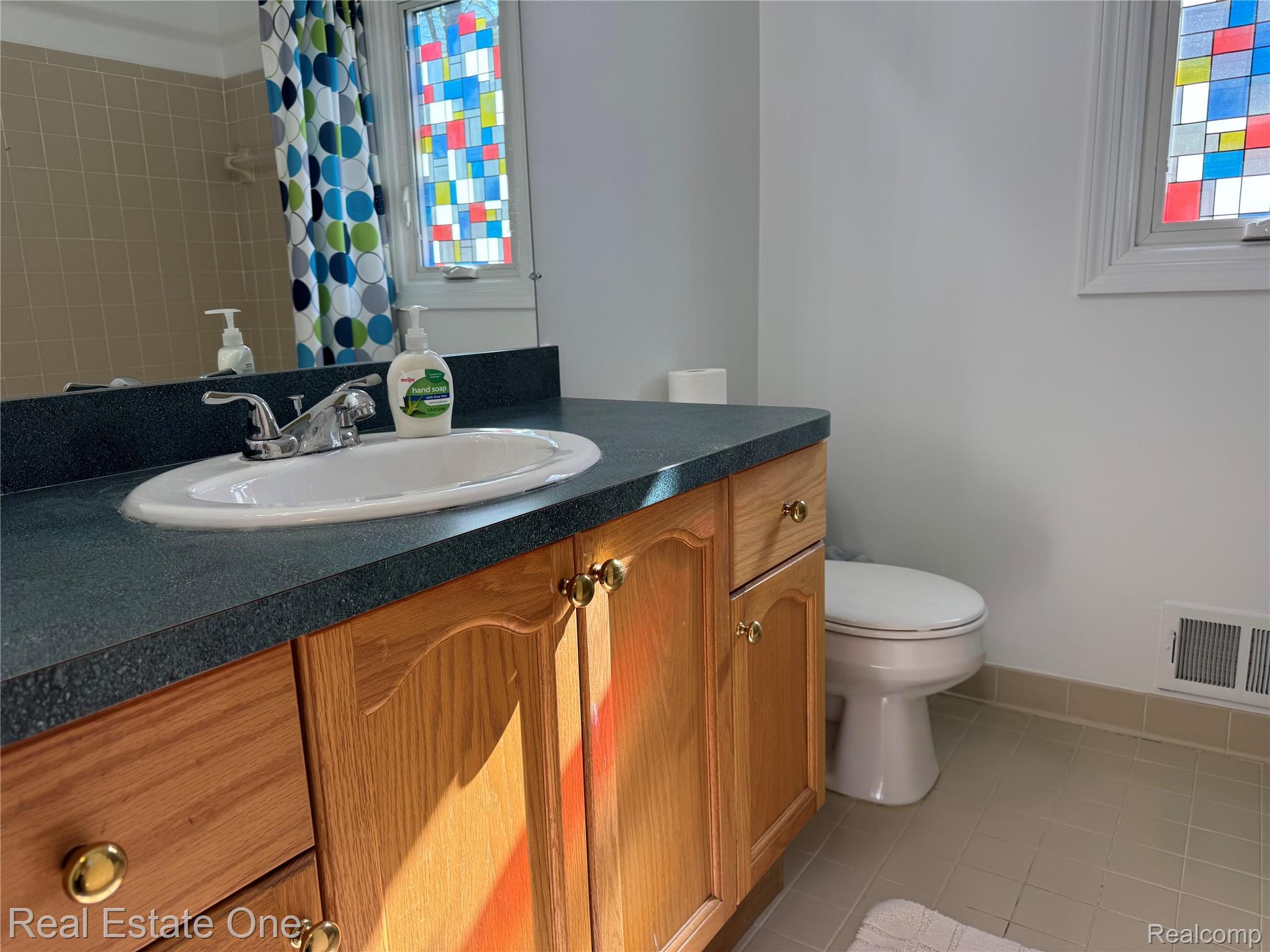 1668 South Shore Drive Rochester, MI 48307 - Photo 18 of 27 Full bathroom featuring vanity, curtained shower, and light tile patterned floors