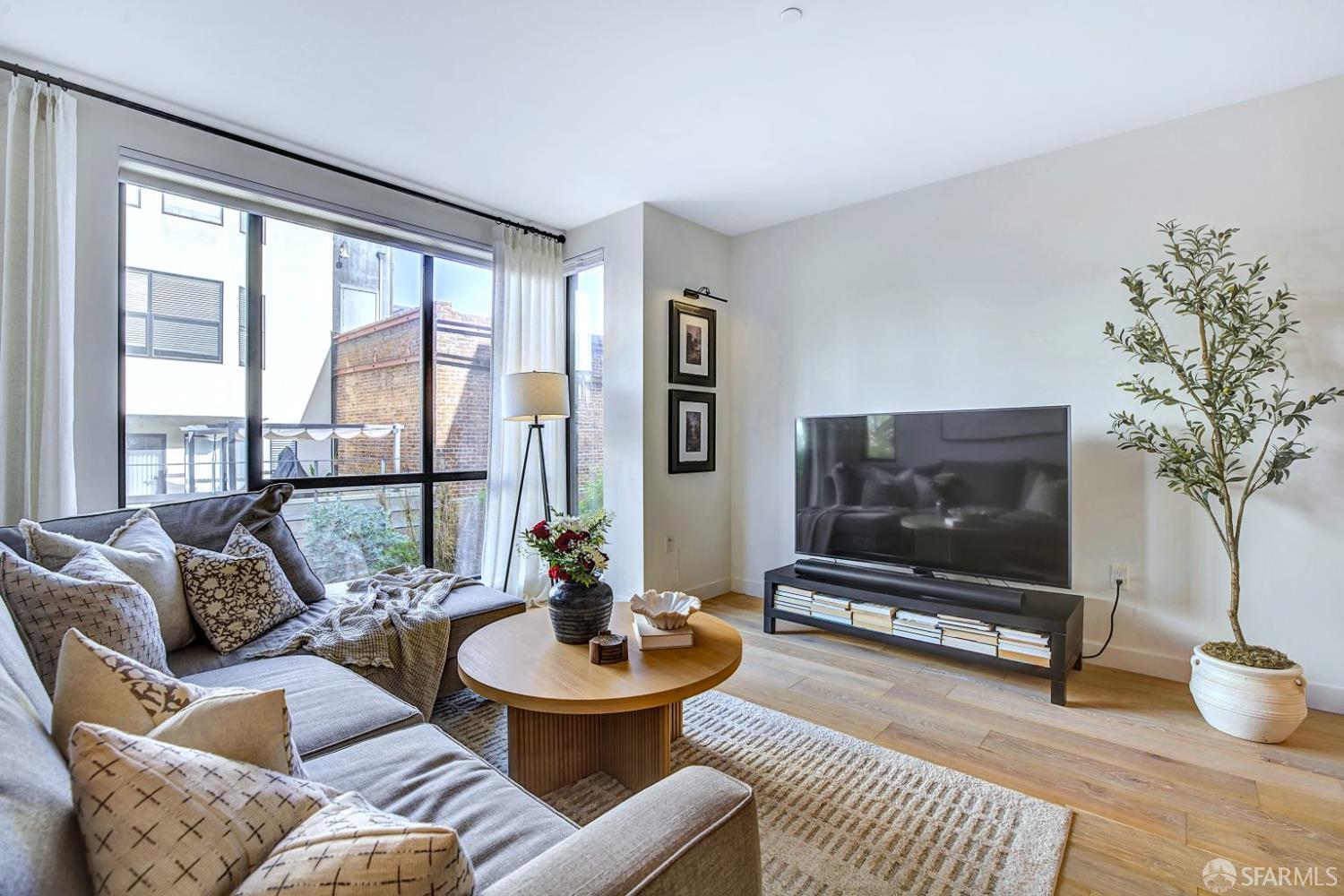 99 Rausch Street, Unit 214 San Francisco, CA 94103 - Photo 17 of 73 a living room with furniture a flat screen tv and a large window