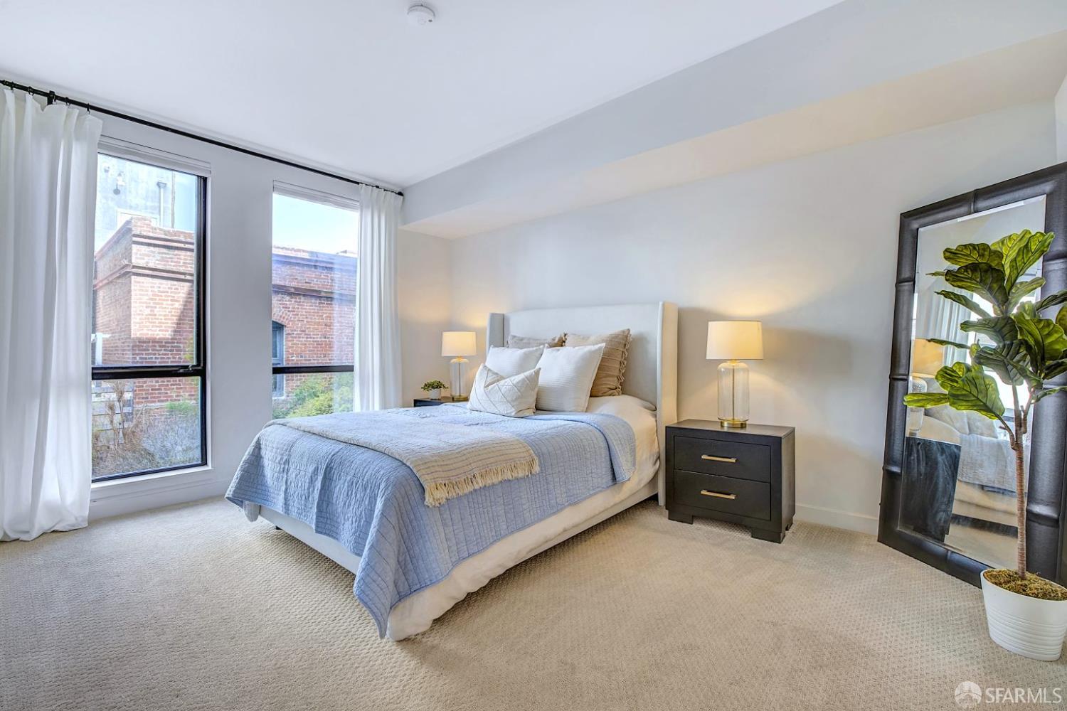 99 Rausch Street, Unit 214 San Francisco, CA 94103 - Photo 28 of 73 a spacious bedroom with a bed and a dresser next to a window