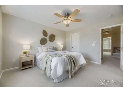 a bedroom with a bed and painting on the wall