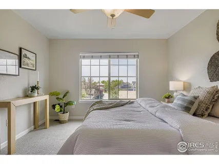 a bedroom with a bed a chandelier a mirror and a window