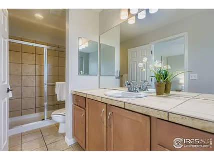 a bathroom with a granite countertop sink a toilet and shower