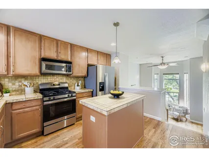 a kitchen with kitchen island granite countertop a sink stainless steel appliances and cabinets