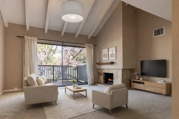 a living room with furniture a flat screen tv and a fireplace
