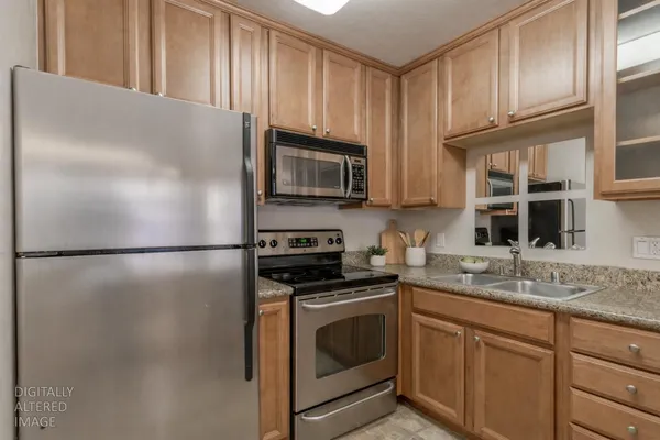 a kitchen with granite countertop a refrigerator stove and microwave