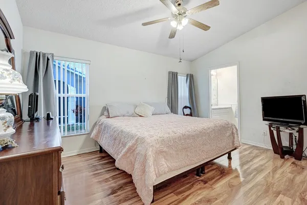 a bedroom with a large bed and a chandelier