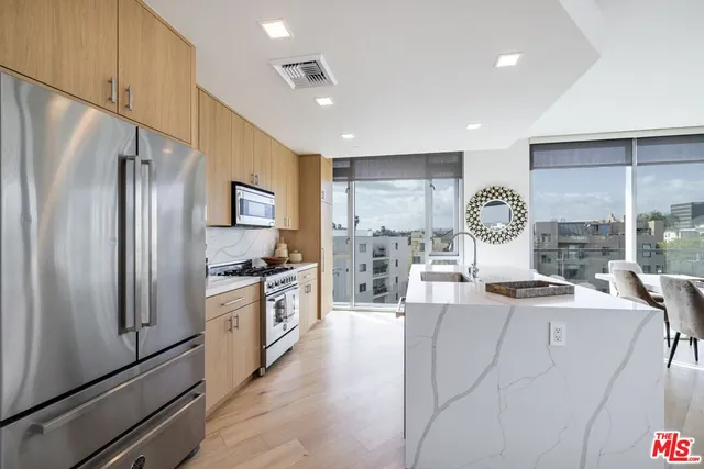 a kitchen with stainless steel appliances granite countertop a refrigerator sink and stove