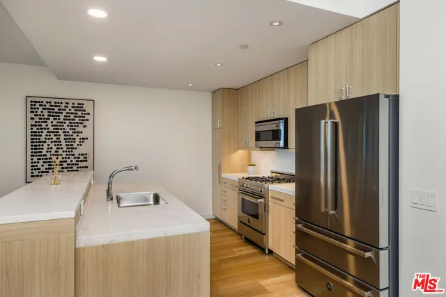 a kitchen that has a refrigerator a stove and a sink