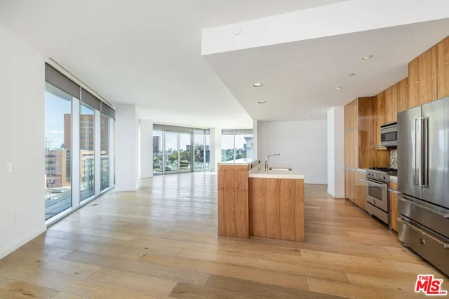 a living room with furniture large windows and wooden floor