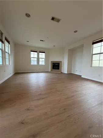 a view of kitchen with microwave a refrigerator and wooden floor