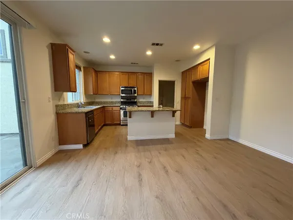 a kitchen with stainless steel appliances granite countertop a stove a sink and a refrigerator