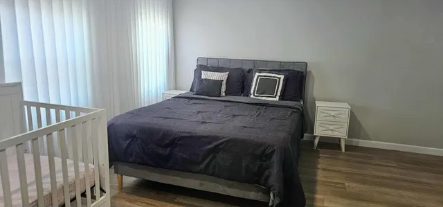 a bedroom with a bed and wooden floor